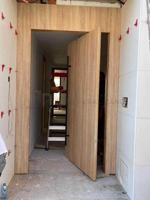 Instalación de puerta de entrada pivotante a medida en Madrid | Carpintería en madera